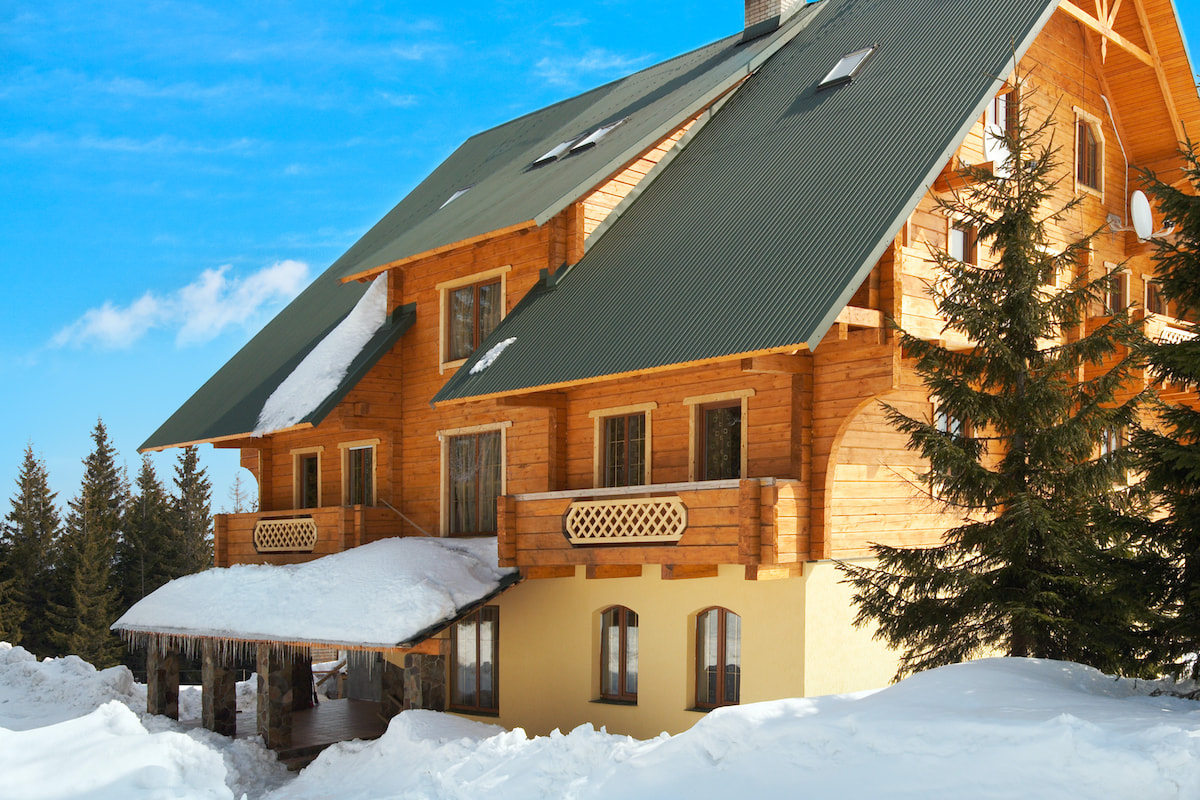 Schönes großes Holzhaus in einer Winterlandschaft.
