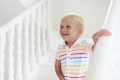 lachendes Kleinkind steht auf Treppe